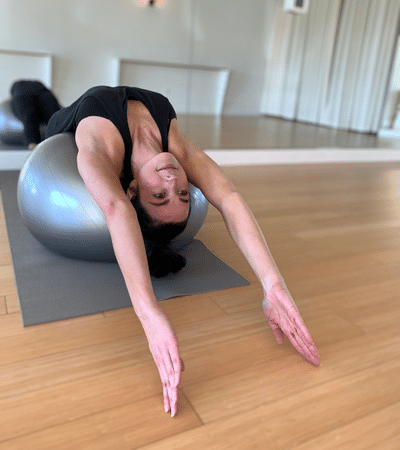 Student doing a backbend on a medicine ball