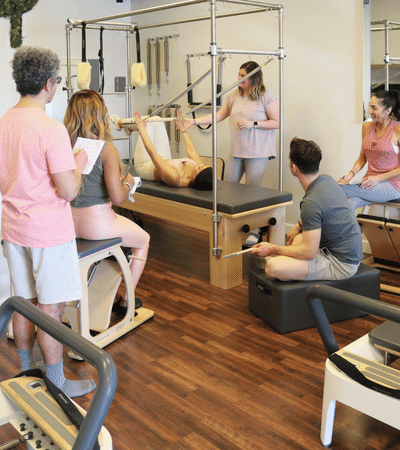 Students watching pilates studio instructor during class