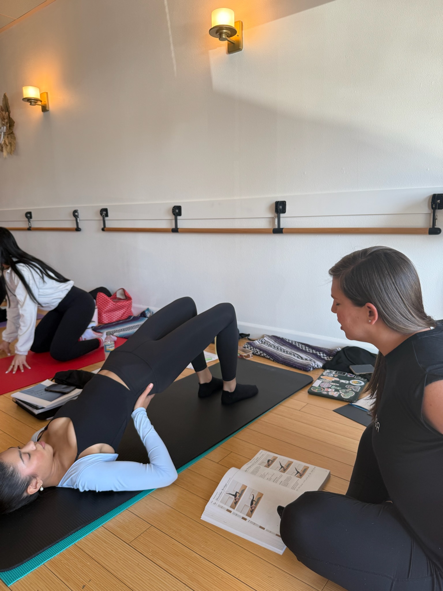 Pilates Teacher Training student teaching another student shoulder bridge