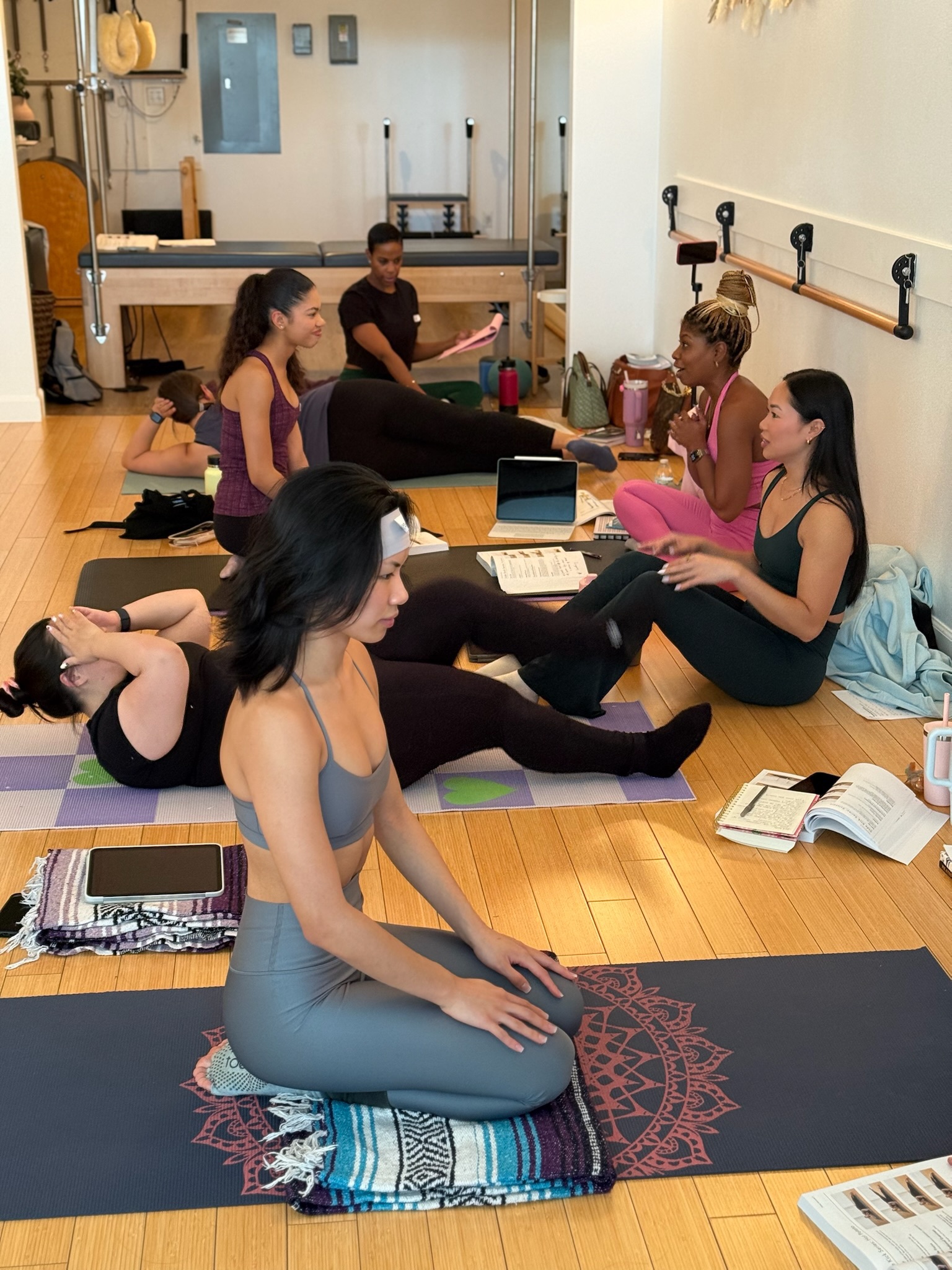 Pilates Teacher Training students talking on their mats