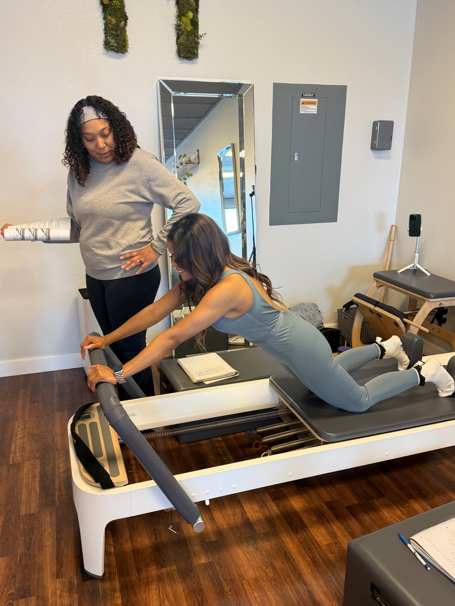 IMG_1945 girl teaching student down stretch on the pilates reformer